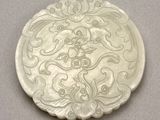 a white plate with a design on it on a table