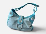 sac à main en cuir bleu sur fond blanc, avec des découpes sur la bandoulière
