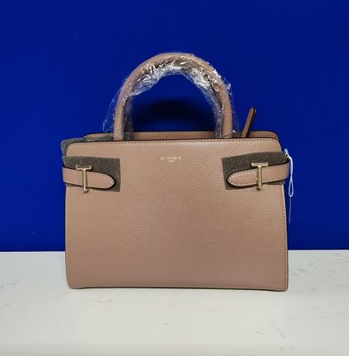 un petit sac à main rose muni d'une poignée en forme de serpent, posé sur une table