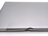 a dell laptop computer sitting on top of a white table