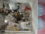 a white box filled with assorted items and a person ' s hand