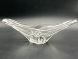 clear glass bowl sitting on top of a table with a black background