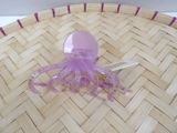 a small purple octopus sitting on top of a woven basket