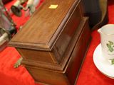 a small wooden box on a red table with a cup and saucer