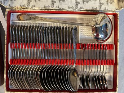 des couverts dans une boîte munie de poignées rouges et contenant des cuillères