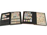 un livre ouvert, orné de timbres, posé sur une surface blanche