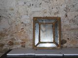a mirror sitting on top of a table in front of a wall
