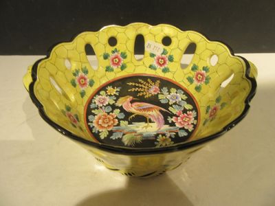 a yellow bowl with a bird on it on a table