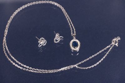 un gros plan d'un ensemble composé d'un collier et de boucles d'oreilles posé sur une table