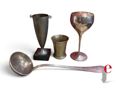 une tasse en argent, une cuillère en argent et une tasse en argent sur fond blanc