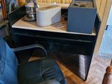 a desk with a computer and a chair in the room