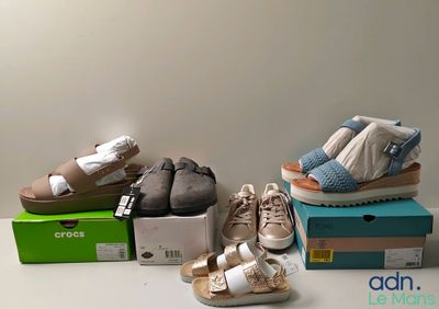 plusieurs paires de chaussures pour bébé posées sur des cartons, sur une table