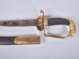 an old sword with a gold handle on a white surface