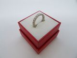 une bague en diamant dans un écrin rouge posé sur une surface blanche