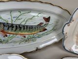 a plate with a fish painted on it next to a plate with a fish on it