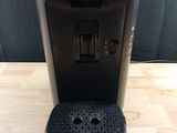 a close up of a coffee maker on a wooden table