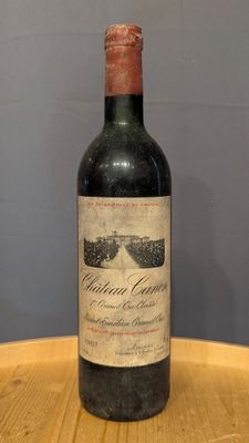 une bouteille de vin posée sur un tonneau en bois