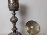 a silver cup sitting on top of a table next to a mirror