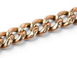 a close up of a gold chain on a white background