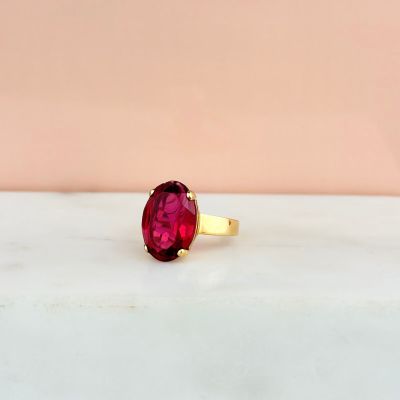 a close up photo of a red stone ring on a marble surface