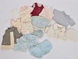 beaucoup de vêtements de bébé posés sur une surface blanche