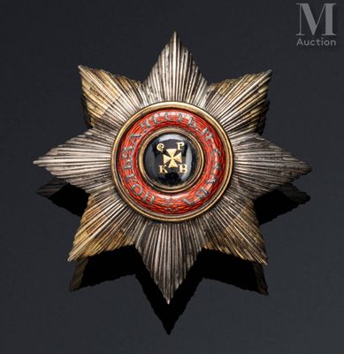 an image of a gold and red star broochle on a black background