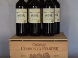quatre bouteilles de vin dans un coffret en bois posé sur une table