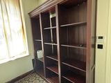 une grande bibliothèque en bois dans un coin de la pièce