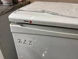 a white refrigerator with a checkered cloth on top of it