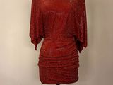 robe rouge à paillettes posée sur un présentoir pour mannequin