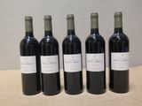 quatre bouteilles de vin sont alignées sur une table