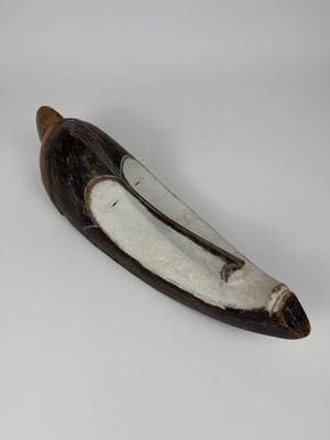 un objet en forme de banane posé sur une surface blanche