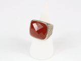 a close up of a ring with a red stone on it