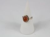 a close up of a ring with a red stone on it