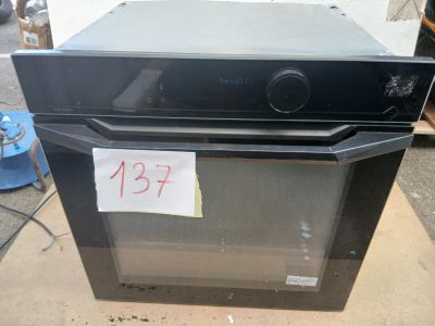 un four noir posé sur une table, avec une étiquette de prix dessus