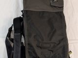 a black bag sitting on a bed next to a cell phone