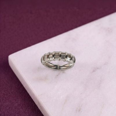 bague en argent massif posée sur une dalle de marbre avec un fond violet