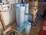 plusieurs rouleaux de plastique bleu posés sur une palette dans un garage