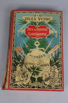 an old book sitting on top of a table next to a white table