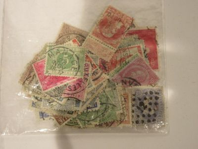 de nombreux timbres différents dans un sachet transparent posé sur la table