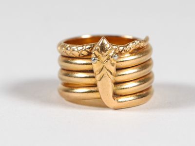 a close up of a gold ring with a leaf on it
