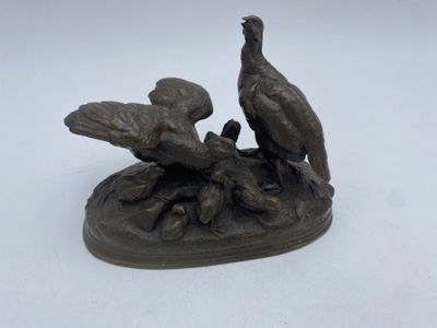 a bronze statue of two birds sitting on a tree branch