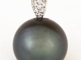an image of a black pearl and diamond pendant on a white background