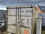 un bac blanc posé par terre à côté d'une clôture