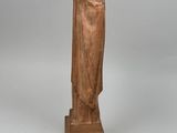 statue of a woman with a veil on her head, standing on a wooden base