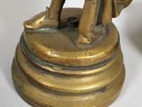 a bronze statue of a woman holding a bag