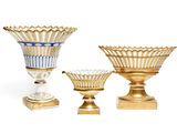 three gold vases sitting next to each other on a white surface