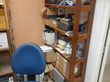 a blue chair sitting in front of a bookshelf in the corner of a room