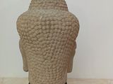 sculpture of a head of a buddha on a black stand