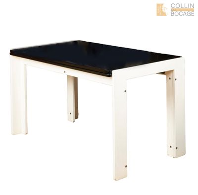 La table est en bois et possède un plateau en verre noir.